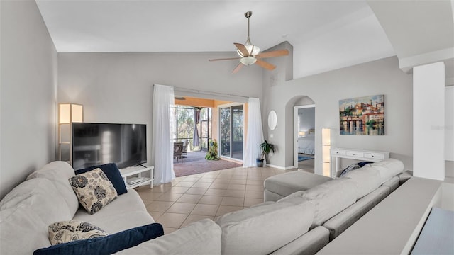 living area featuring tile patterned floors, baseboards, high vaulted ceiling, and a ceiling fan