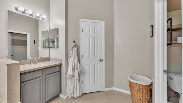 bathroom with baseboards, toilet, vanity, and tile patterned flooring