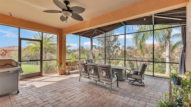 unfurnished sunroom featuring a ceiling fan