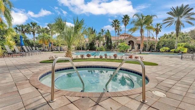 community pool featuring a community hot tub and a patio area