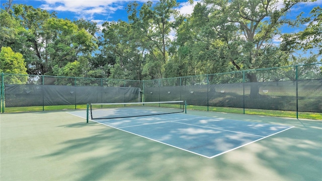 view of tennis court featuring fence