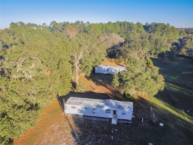 birds eye view of property with a view of trees