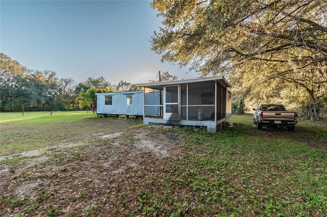 view of front of property featuring a sunroom and a front lawn