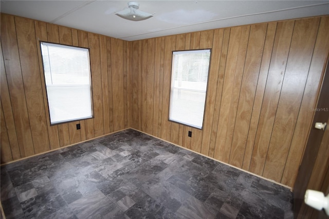 unfurnished room featuring wood walls