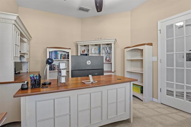 carpeted office space featuring ceiling fan