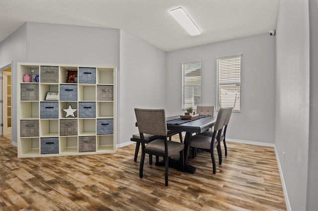 dining area featuring wood-type flooring and a textured ceiling