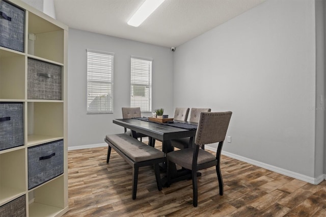 dining space with a textured ceiling and wood-type flooring