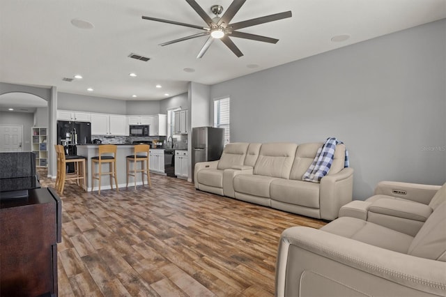 living room with ceiling fan and wood-type flooring