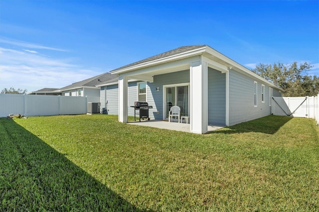 back of house with a patio, a yard, and central air condition unit