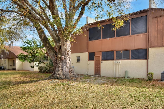 exterior space with central AC and a yard