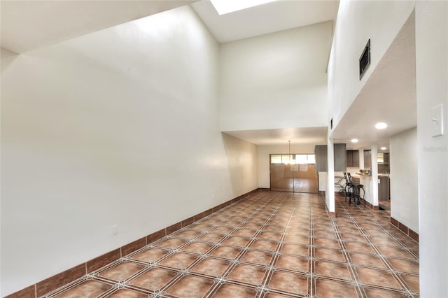 unfurnished living room with a towering ceiling and a notable chandelier