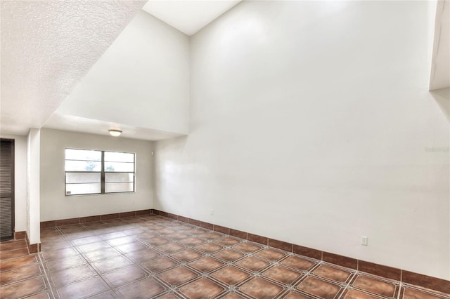 spare room with a textured ceiling and a high ceiling