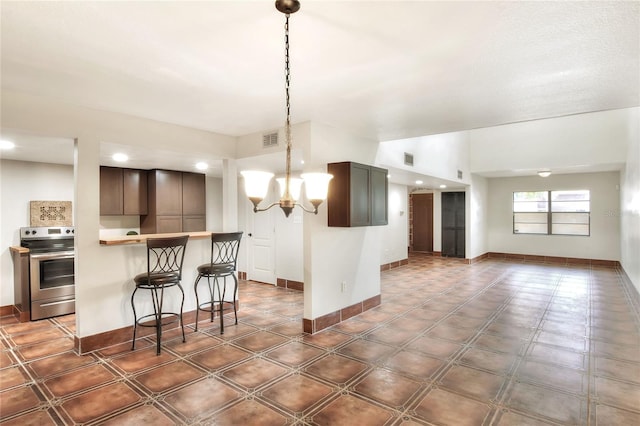 kitchen with stainless steel range with electric stovetop, dark brown cabinets, a kitchen bar, kitchen peninsula, and a chandelier