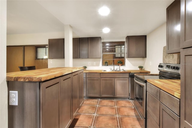 kitchen featuring stainless steel electric range oven, dark brown cabinets, butcher block counters, and sink