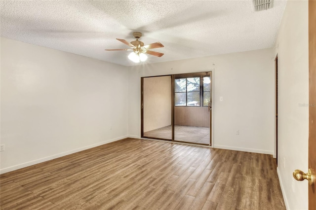 unfurnished bedroom featuring hardwood / wood-style flooring, ceiling fan, a textured ceiling, and a closet