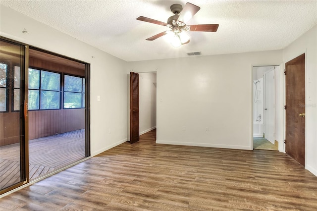 unfurnished room with wood-type flooring, ceiling fan, and a textured ceiling