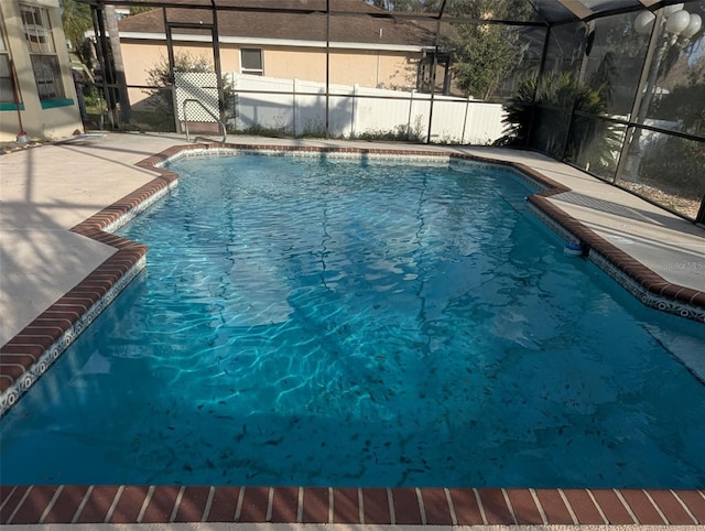 view of swimming pool featuring a lanai and a patio