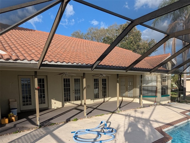 back of property with a lanai, a patio area, ceiling fan, and french doors