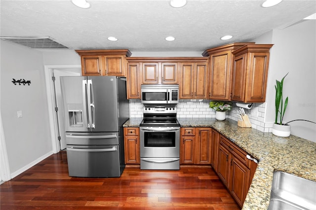 7410 Locksley Ln, Lakeland, FL 33809 - kitchen with appliances with stainless steel finishes, visible vents, and brown cabinets