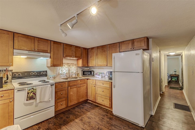 kitchen featuring dark hardwood / wood-style flooring, sink, a textured ceiling, and white appliances