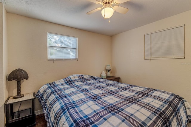 bedroom featuring a textured ceiling, dark wood-type flooring, and ceiling fan