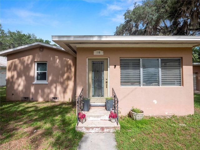 bungalow with entry steps, crawl space, a front yard, and stucco siding