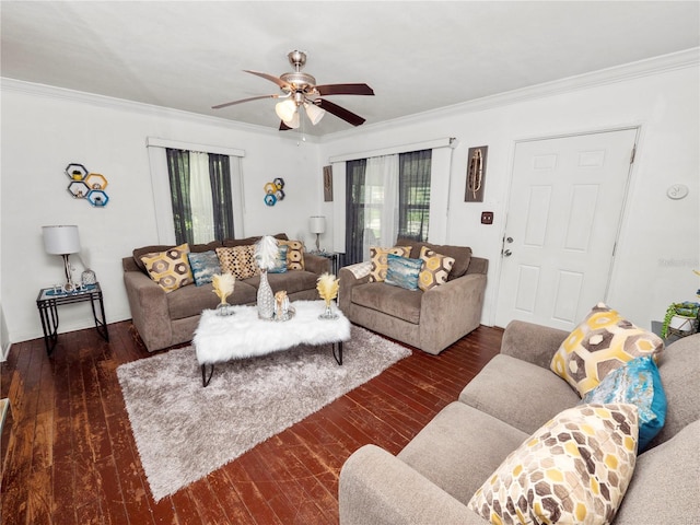 living area with ornamental molding, dark wood finished floors, and a ceiling fan