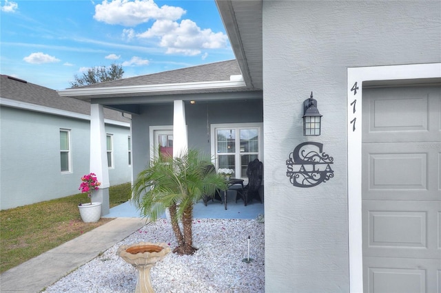 doorway to property with a porch and a garage