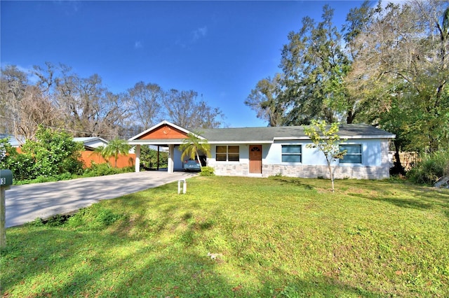 ranch-style house featuring concrete driveway, stone siding, a carport, and a front yard