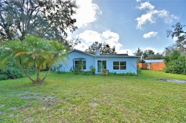 rear view of property with a yard