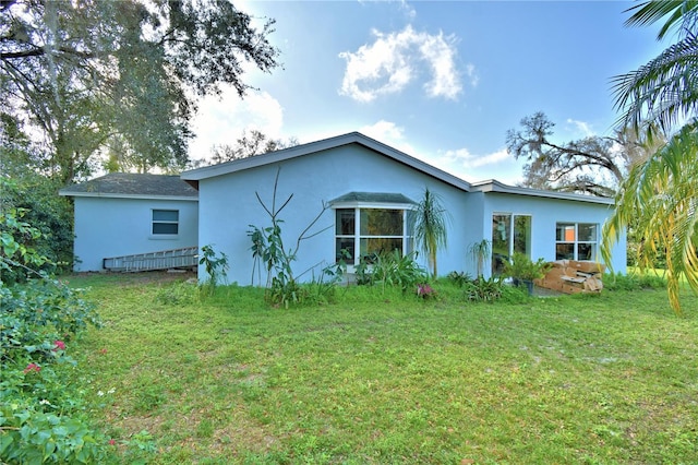 rear view of house featuring a lawn