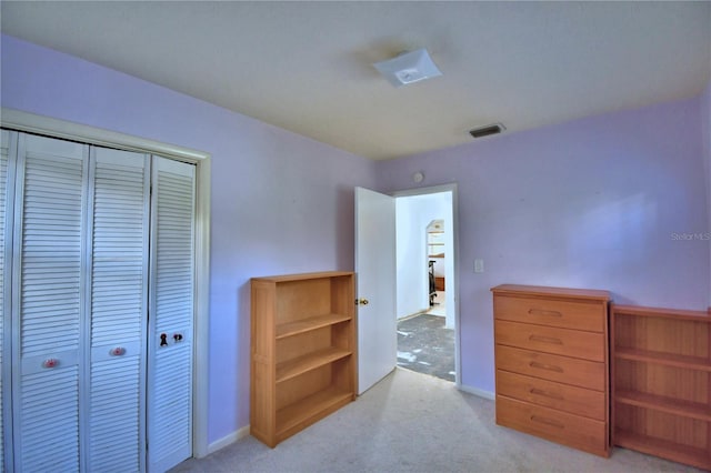 bedroom with a closet and light carpet