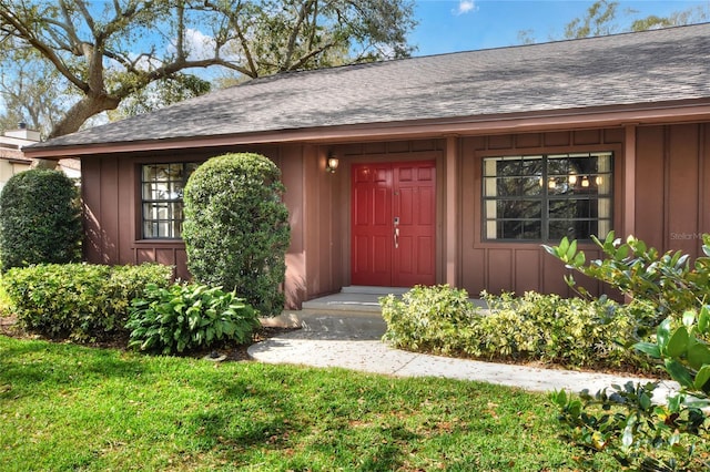 property entrance with a lawn