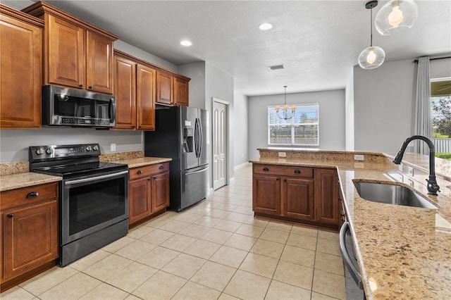 kitchen with decorative light fixtures, light tile patterned floors, stainless steel appliances, visible vents, and a sink