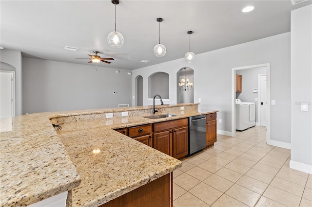 kitchen with arched walkways, light tile patterned flooring, a sink, brown cabinets, and dishwasher