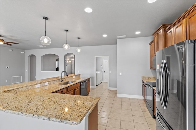 kitchen featuring black appliances, visible vents, brown cabinets, and a sink