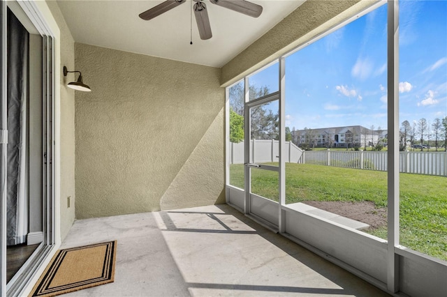 unfurnished sunroom featuring a healthy amount of sunlight and ceiling fan