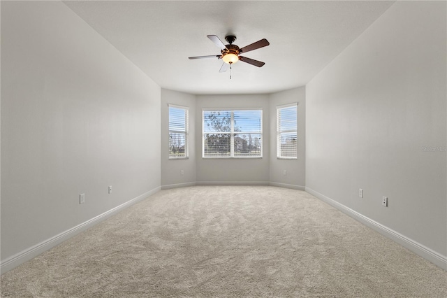 empty room with light carpet, ceiling fan, and baseboards