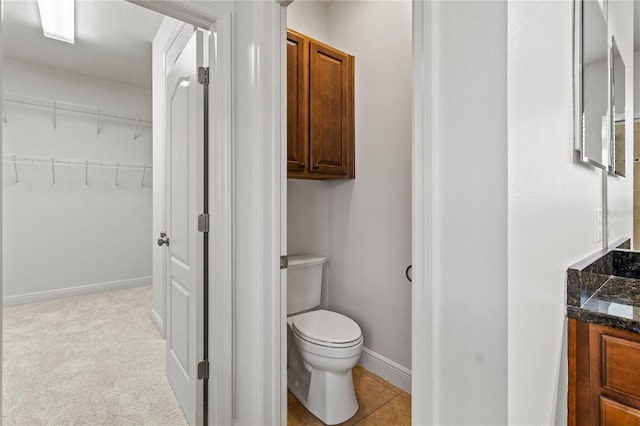 bathroom with baseboards, vanity, and toilet