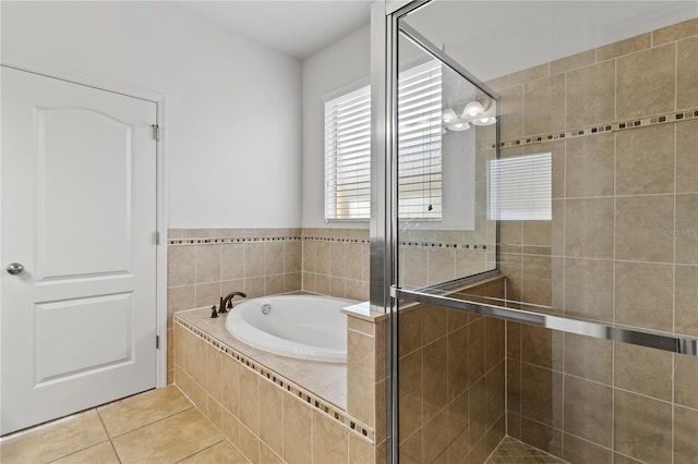 full bath featuring a stall shower, a garden tub, and tile patterned floors