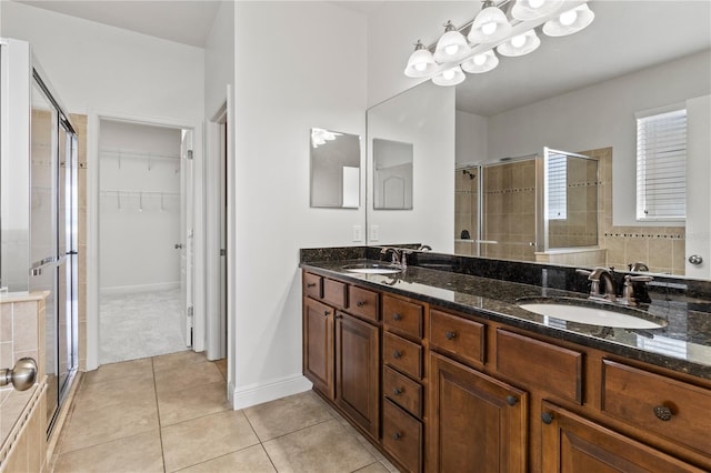 full bath featuring a stall shower, a sink, and tile patterned floors