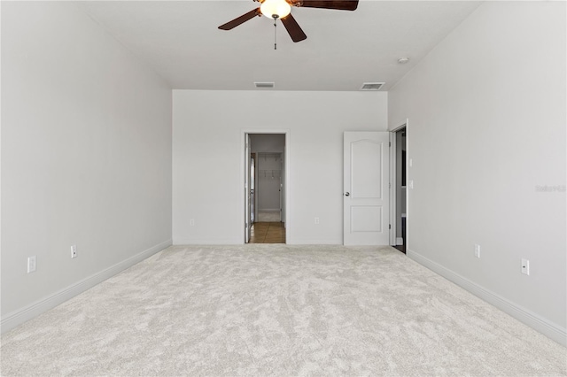 unfurnished bedroom featuring carpet floors, a spacious closet, visible vents, and baseboards