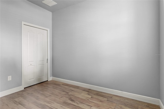 empty room featuring light wood finished floors and baseboards