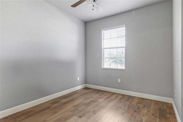 empty room featuring ceiling fan, baseboards, and wood finished floors