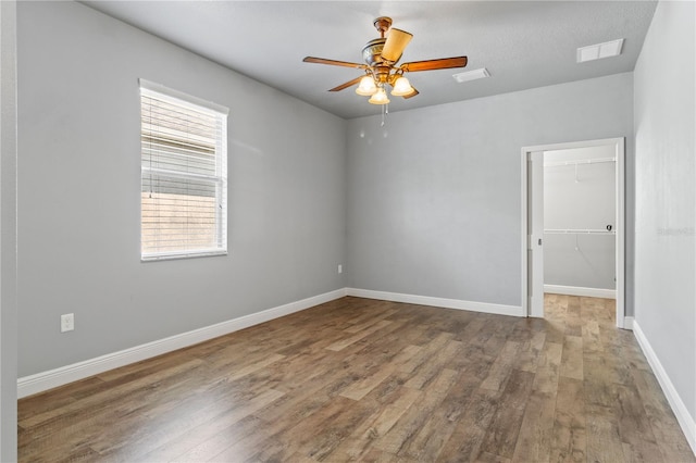 spare room with visible vents, baseboards, and wood finished floors