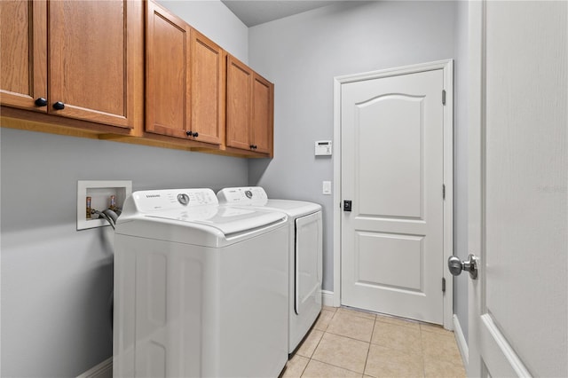 laundry room with light tile patterned floors, washer and clothes dryer, cabinet space, and baseboards