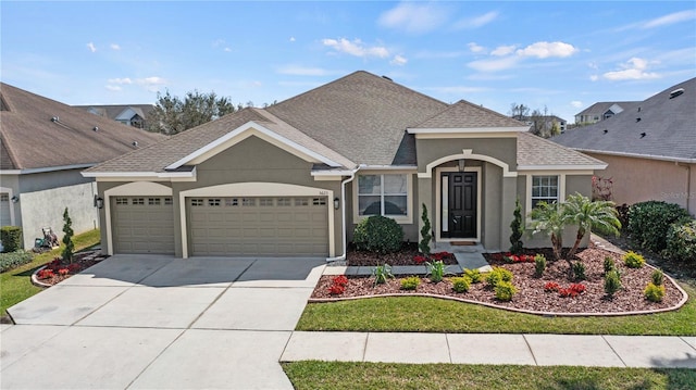 view of front of home featuring an attached garage, a shingled roof, concrete driveway, and stucco siding