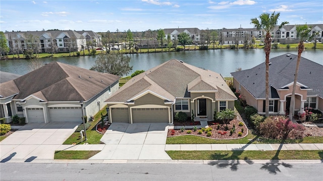 view of front facade featuring an attached garage, a water view, and a residential view