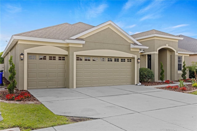 ranch-style house featuring a garage, driveway, roof with shingles, and stucco siding