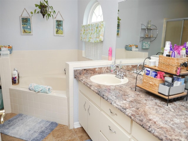 bathroom featuring tile patterned flooring, a garden tub, vanity, and a shower stall